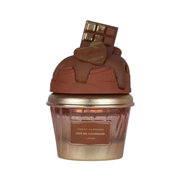 Frasco con forma de cupcake: base acanalada de vidrio rosado con reborde dorado y una cúpula de chocolate esculpida rematada por una tableta, sobre fondo blanco.