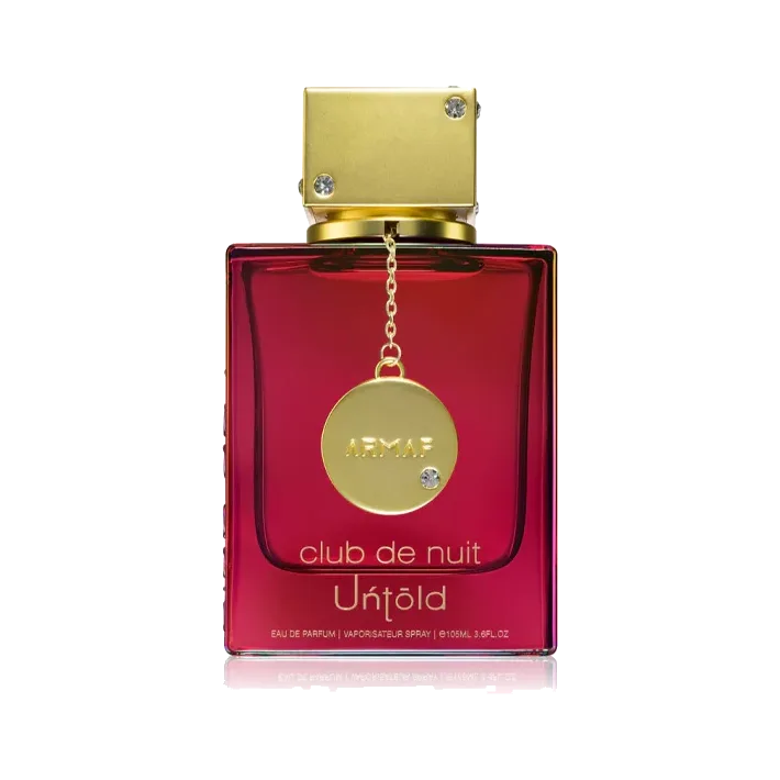Frasco rectangular de vidrio rojo rubí con tapa dorada con cristales y un medallón dorado colgando de una cadena, sobre fondo blanco.