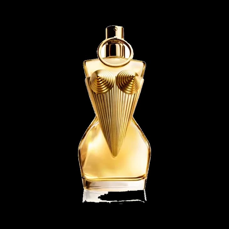 Frasco con forma de busto femenino en vidrio dorado, con corsé de varillas metálicas y un asa circular sobre el tapón, sobre fondo blanco.