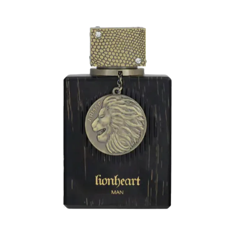 Frasco rectangular negro con vetas de madera, tapa dorada con textura de escamas y un medallón de bronce con cabeza de león colgando de una cadena, sobre fondo blanco.