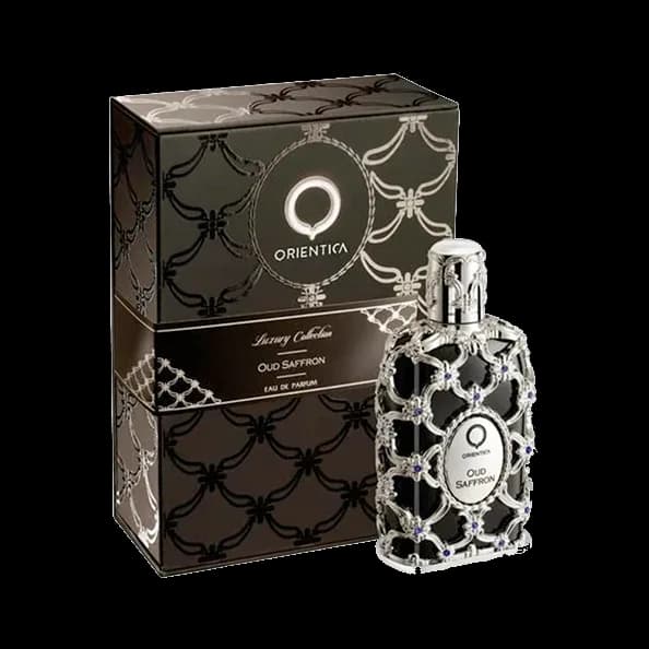 Frasco rectangular negro envuelto en filigrana plateada con un medallón ovalado al frente, junto a su estuche negro con enrejado plateado, sobre fondo blanco.