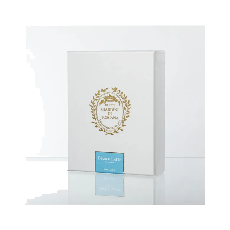 El estuche blanco cerrado con un escudo dorado y una etiqueta celeste, sin el frasco a la vista, sobre fondo blanco con reflejo.