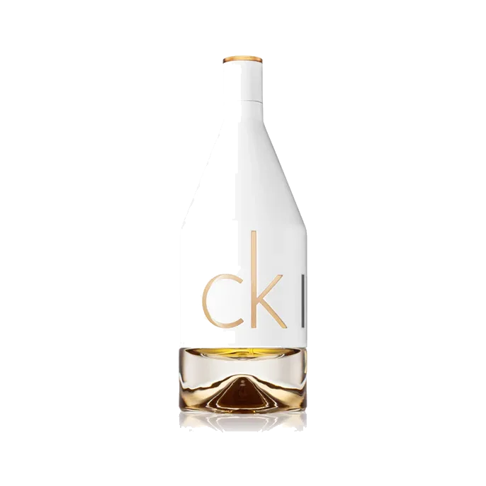 Frasco alto de hombros caídos, mitad superior blanca opaca con letras doradas y base de vidrio transparente con líquido ámbar, sobre fondo blanco.