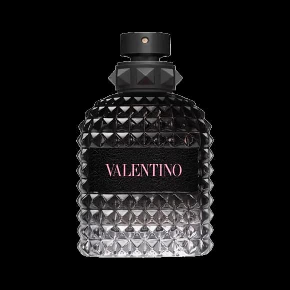 Frasco cuadrado con relieve de tachuelas piramidales, degradado de negro a transparente, etiqueta negra con letras rosadas y tapón negro con tachuelas, sobre fondo blanco.