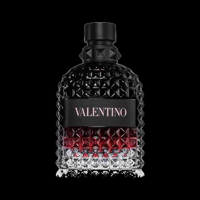 Frasco cuadrado con relieve de tachuelas piramidales, degradado de negro a rojo y a transparente, etiqueta negra y tapón negro, sobre fondo blanco.